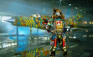 A MiG-21 military flight suit is being modeled by a woman of African descent. She is covered in a brightly colored tribal-inspired armor featuring colorful beads.